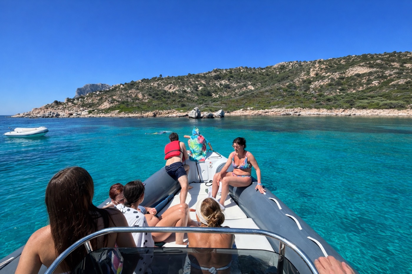 Gruppo a bordo del gommone nelle acque cristalline di Molara